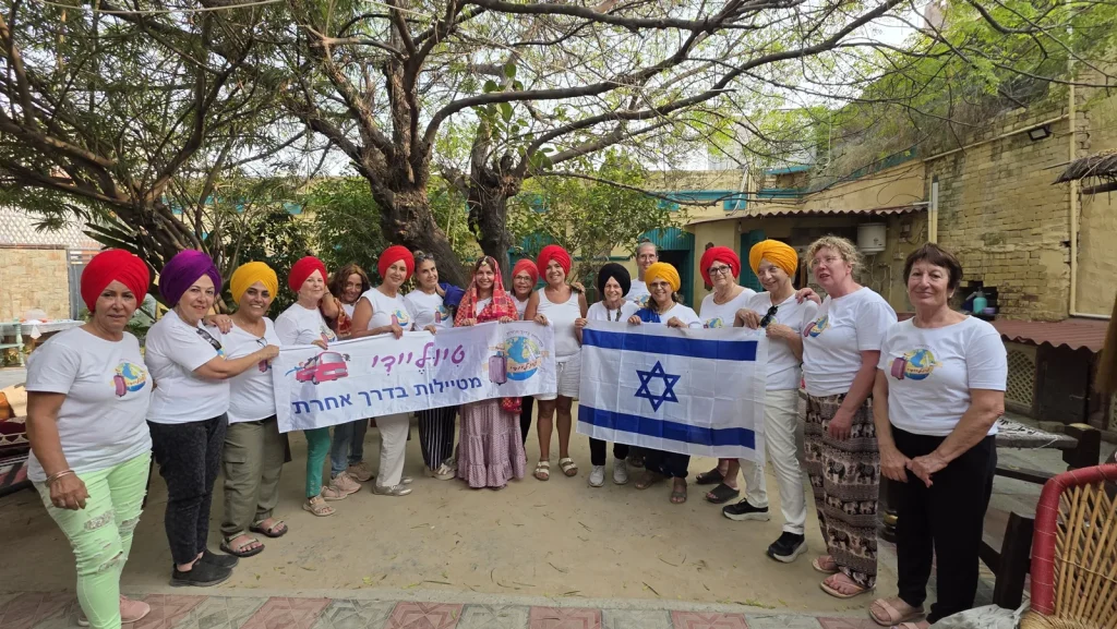 קבוצת טיוליידי בטורבנים צבעוניים עם השלט ודגל ישראל
